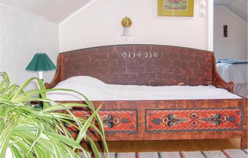 een houten bed in een kamer met een plant bij Gorgeous Home In Enviken With Wifi in Enviken