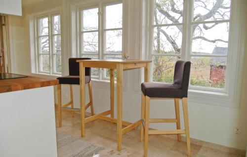 a kitchen with a wooden table and two chairs at Lovely Home In Mellerud With Kitchen in Mellerud