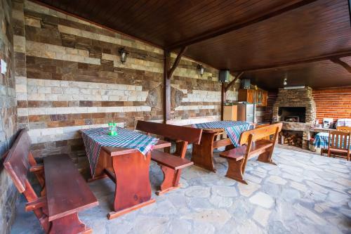 a patio with wooden tables and chairs and a fireplace at Guest House Holiday in Ognyanovo