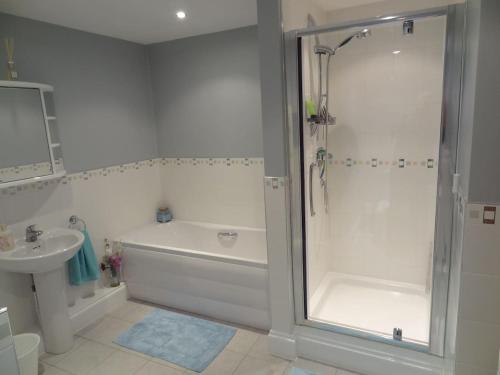 y baño con ducha, bañera y lavamanos. en Birchwood House en Church Stretton