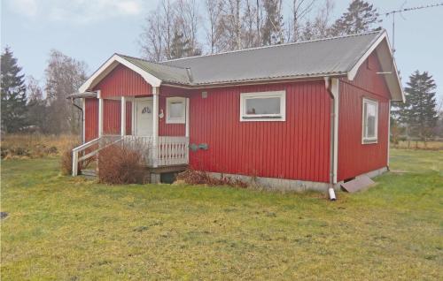 una casa rossa in un campo con un cortile di Two-Bedroom Holiday Home In Löttorp a Löttorp