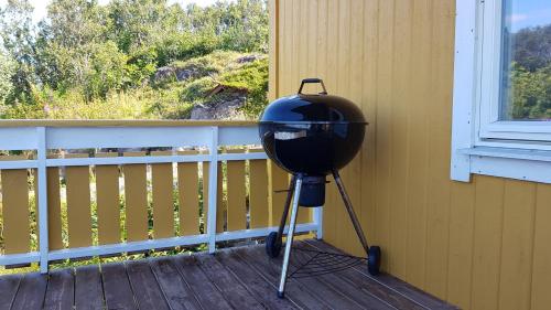 a grill sitting on a porch next to a window at Farmer Apartment in Laukvik