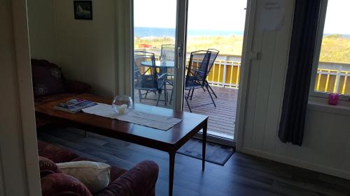 a living room with a table and a balcony at Farmer Apartment in Laukvik