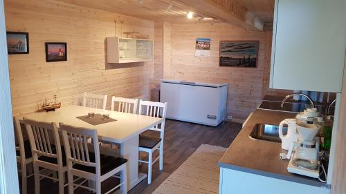 a small kitchen with a table and a refrigerator at Farmer Apartment in Laukvik