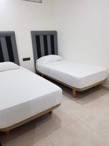 dwa łóżka siedzące obok siebie w pokoju w obiekcie Saramica Seaside apartment w mieście Al-Funajdik