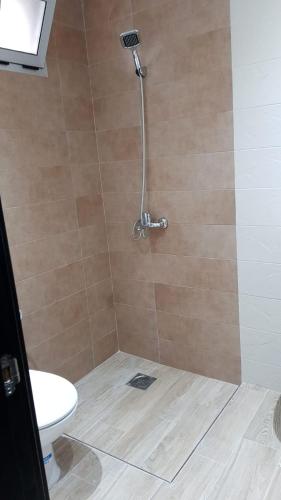La salle de bains est pourvue d'une douche et de toilettes. dans l'établissement Saramica Seaside apartment, à Fnideq
