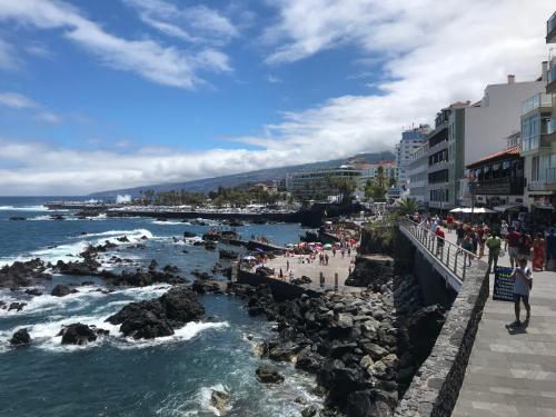 eine Gruppe von Menschen an einem Strand in der Nähe des Ozeans in der Unterkunft Apartamento céntrico Santa Cruz de Tenerife in Santa Cruz de Tenerife