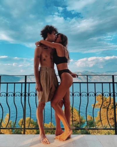 a man and a woman standing on a balcony kissing at THE VIEW **** in Račišće