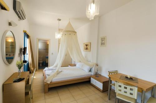 een slaapkamer met een bed met een klamboe bij Votsalo in Astypalaia-stad (Chora)