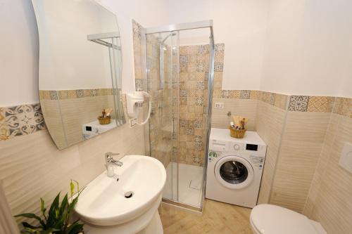 une salle de bain avec un lavabo et une machine à laver dans l'établissement MON REVE, à Agerola