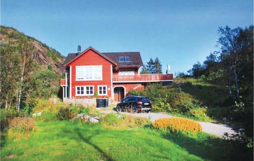 a red house with a car parked in front of it at Awesome Home In Svolvær With Wifi in Svolvær