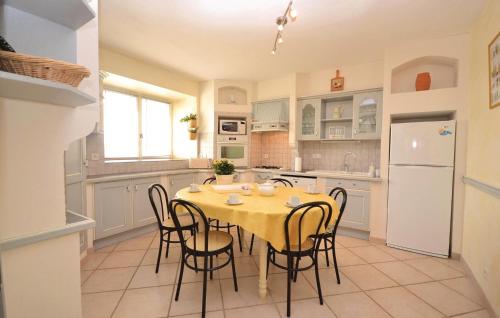 a kitchen with a table and chairs and a refrigerator at Lovely Home In Montbrison Sur Lez in Peyrol