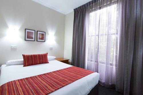 a hotel room with a bed and a window at Barkly Motorlodge in Ballarat