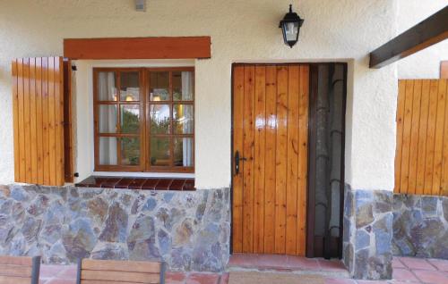 una casa con due porte in legno e una finestra di Beautiful Home In Lametlla Del Valles With Outdoor Swimming Pool a Bigues i Riells