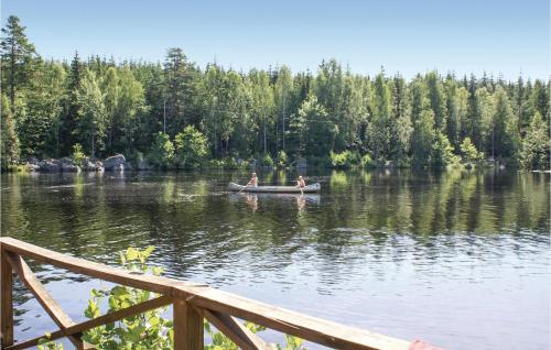 two people are in a boat on a lake at Beautiful Home In Tingsryd With Sauna in Tingsryd
