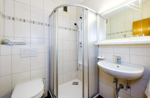 a bathroom with a shower and a toilet and a sink at Tyrol Appartements in Ehrwald