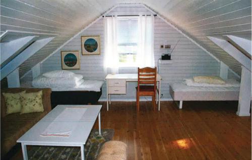 スヴォルヴァールにあるBeautiful Home In Svolvr With 4 Bedrooms And Wifiのベッド2台とデスクが備わる屋根裏部屋