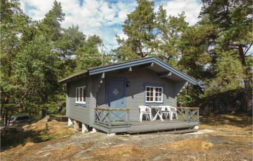 a small blue shed with two chairs on the porch at Four-Bedroom Holiday Home In Trosa in Trosa