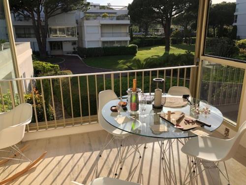 une table en verre et des chaises sur un balcon dans l'établissement Appartement dans résidence d'exception, à Mandelieu-la-Napoule