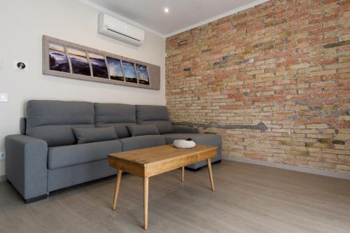 a living room with a couch and a brick wall at Lo passeig in Tremp