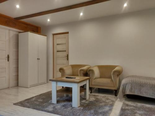 a bedroom with two chairs and a table and a bed at NOCLEGI-SPŁYWY BUGIEM in Sławatycze