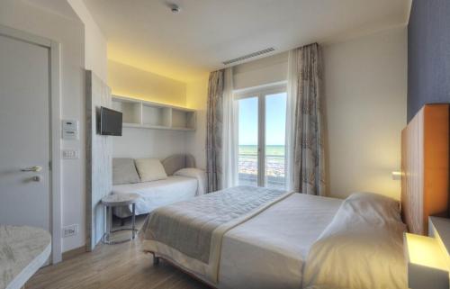 Habitación de hotel con cama y ventana en Gabbiano Hotel, en Civitanova Marche