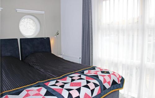 a bedroom with a bed with a quilt on it at Amazing Home In Workum With Wifi in Workum