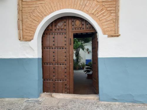 - une entrée pour un bâtiment avec une porte en bois dans l'établissement Casa Rural San blas, à Almagro