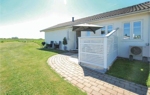 a white house with an umbrella and a lawn at 2 Bedroom Stunning Home In Borgholm in Borgholm