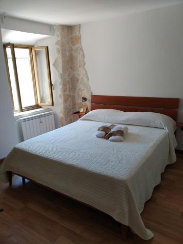 two teddy bears laying on a bed in a bedroom at Historical Domus in Anagni