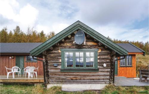 eine Blockhütte mit einem Tisch und Stühlen auf einer Terrasse in der Unterkunft Tallåsen Dagalifjell in Dagali