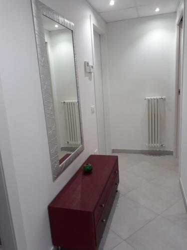 a bathroom with a large mirror and a brown dresser at Belvedere in Policoro