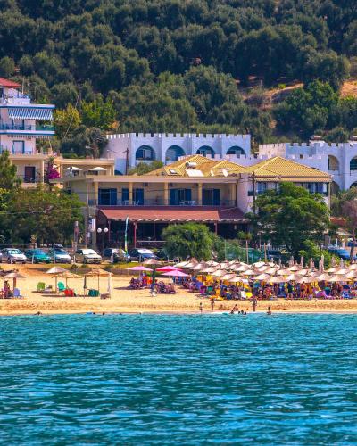 a beach with umbrellas and people on the beach at Hotel Loukas Vrachos in Paralia Vrachou