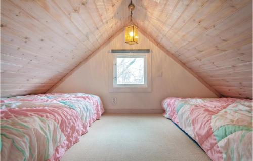 two beds in a attic room with a window at Gorgeous Studio In Visby With Wifi in Fole