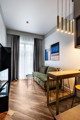 a living room with a couch and a table at Apartamenty Nowa Kamienica Częstochowa Centrum Szymanowskiego 22A in Częstochowa