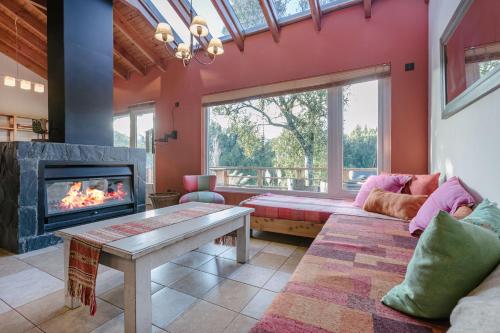 sala de estar con sofá y chimenea en BOG Casa Loma del Sol en Villa La Angostura