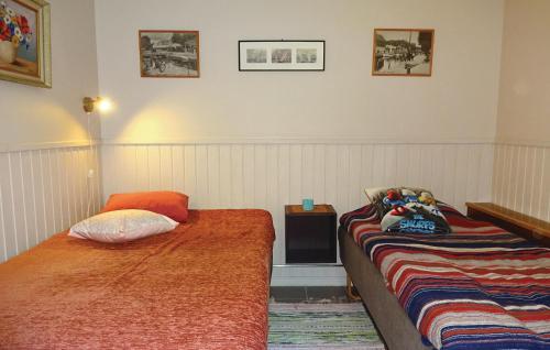 ロンネビューにあるGorgeous Home In Ronneby With House Sea Viewのベッドルーム1室(ベッド2台、テーブル、ぬいぐるみ付)