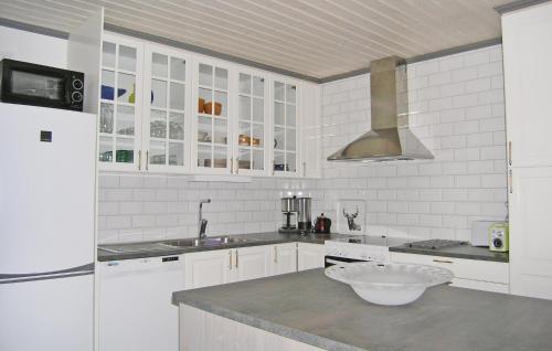 uma cozinha com armários brancos e uma tigela no balcão em Amazing home in Vittaryd with 4 Bedrooms, Sauna and WiFi em Kvänarp