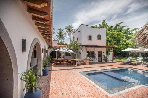 a villa with a swimming pool in front of a house at Villa San Juan Bed&Breakfast in Nuevo Vallarta 