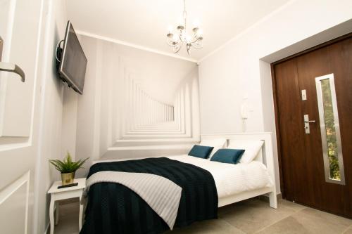 a white bedroom with a bed with blue pillows at GOOD NIGHT | city Police (3km) | Szczecin | 2 pers in Szczecin