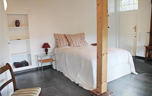 WingstにあるAwesome Apartment In Wingst With Kitchenの白いベッド1台、木製の柱式ベッド1台が備わるベッドルーム1室が備わります。
