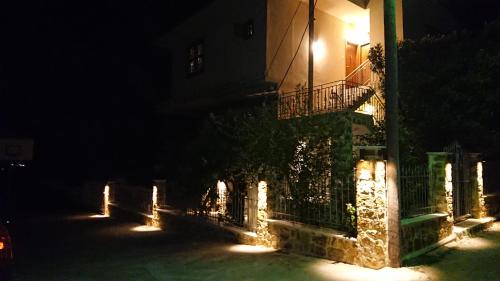 a building with a fence and a balcony at night at Stone house with seaview in Nea Potidaea