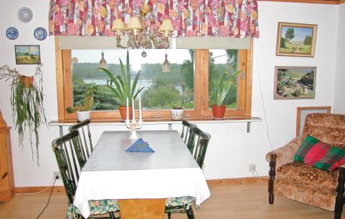 a dining room with a table and chairs and a window at Cozy Home In Strängnäs With Kitchen in Aspö