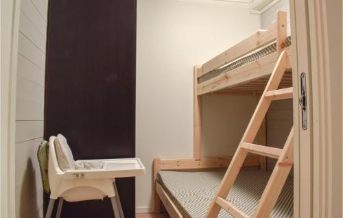 a bedroom with a bunk bed with a desk and a ladder at Awesome Apartment In Hovden in Hovden