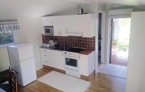 a kitchen with white cabinets and a stove top oven at Lovely Home In Frjestaden With Ethernet Internet in Färjestaden