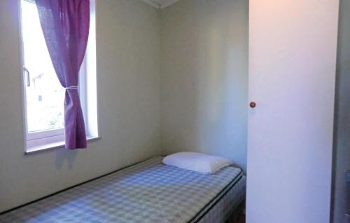 ein kleines Bett in einem Zimmer mit Fenster in der Unterkunft Lovely Home In Frjestaden With Ethernet Internet in Färjestaden
