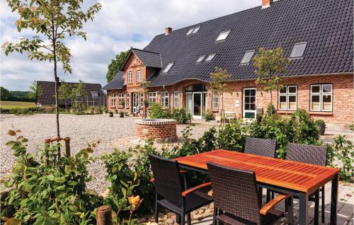 a house with a table and chairs in a courtyard at Cozy Home In Gammelby With Sauna in Gammelby