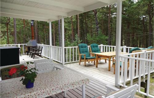 a porch with chairs and a table and a grill at Nice Home In Yngsjö With Wifi in Yngsjö