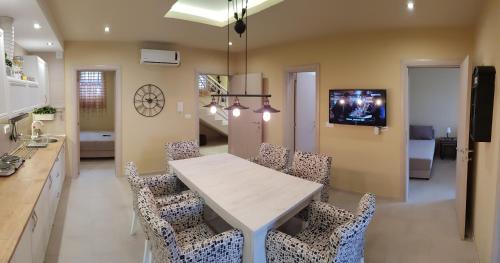 a kitchen and dining room with a white table and chairs at Apartments Exclusive in Belgrade