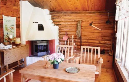 a dining room with a table and a fireplace at Two-Bedroom Holiday Home In Mansarp in MÃ¥nsarp